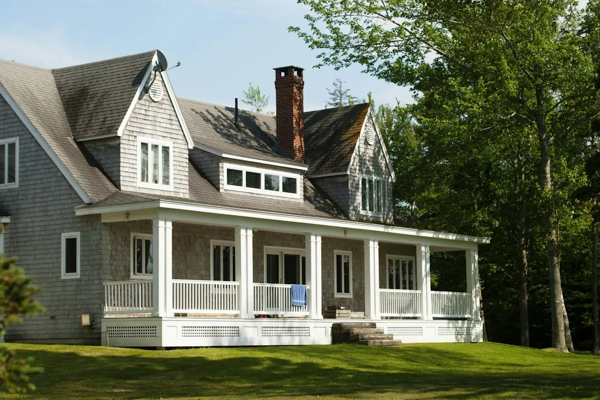 White and brown residential home exterior among trees
