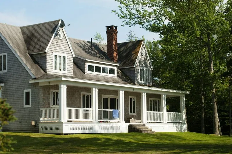 White and brown residential home exterior among trees