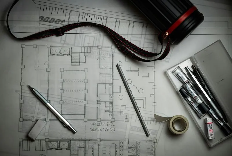 Floor plan drawings with drafting pencils and a scale