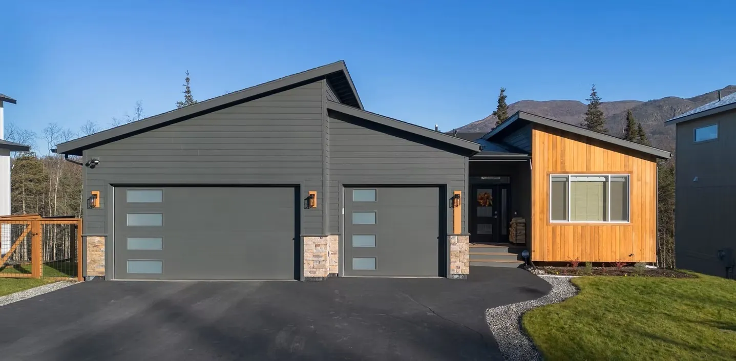 Custom home with dark siding and wood accent siding, site photo