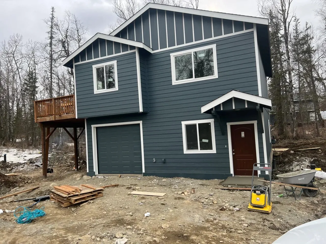 Two-story blue custom home with a side deck, site photo